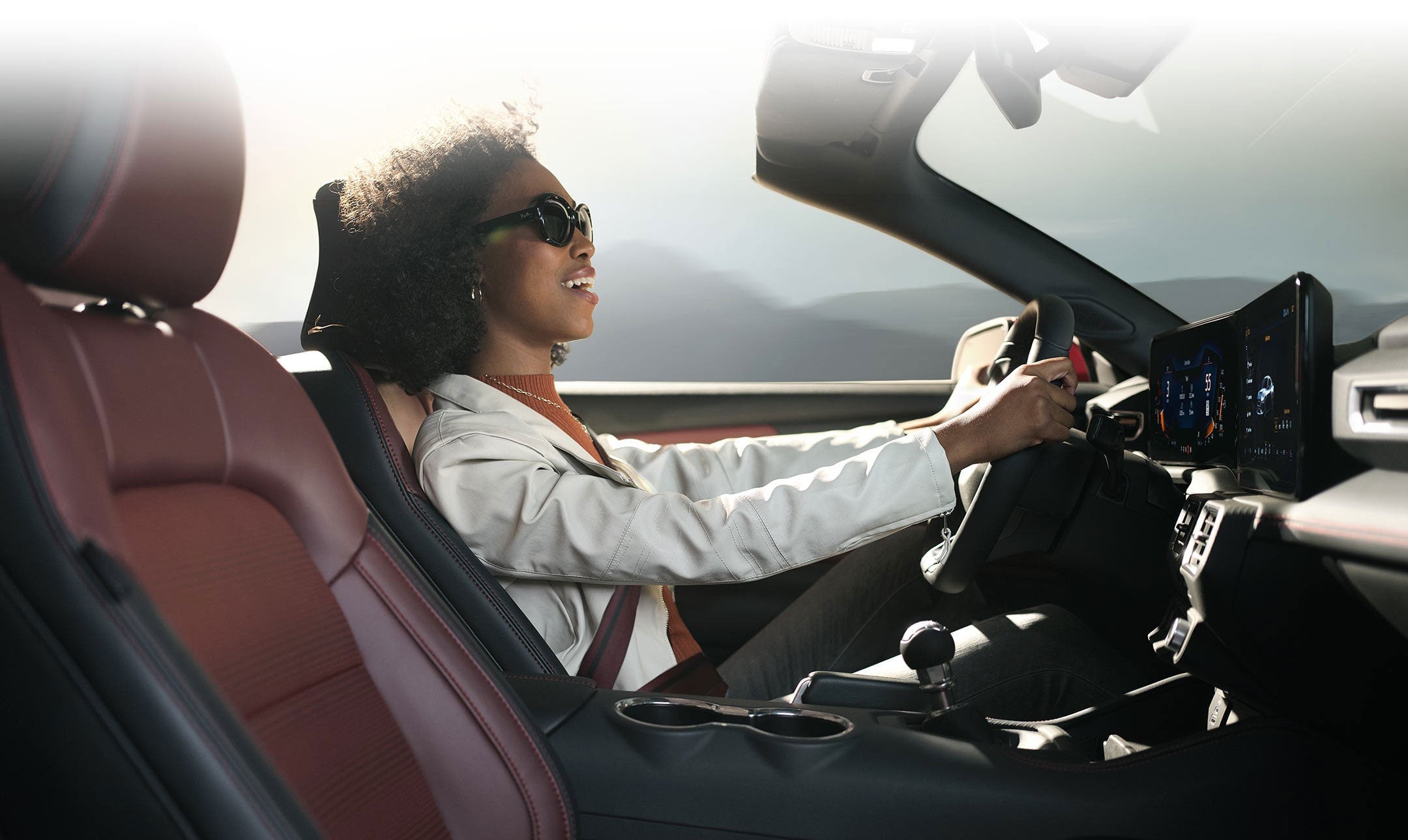 Person sitting in the driver’s seat of a 2024 Ford Mustang® convertible | White's Canyon Ford in Spearfish SD