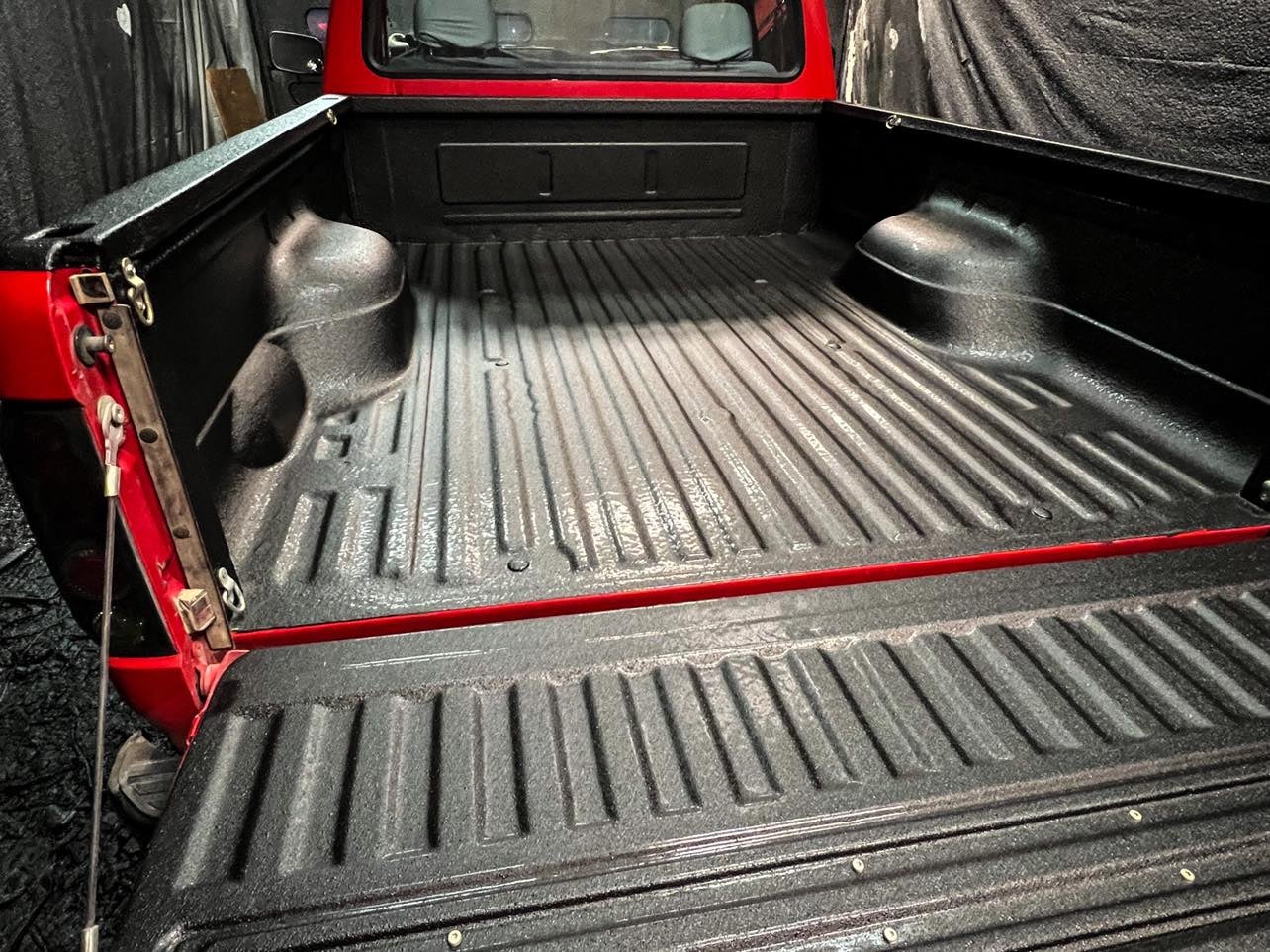 Red truck with ArmorThane spray on truck bed liner