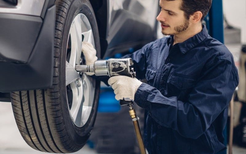 Technician inspecting a vehicle on a lift.
